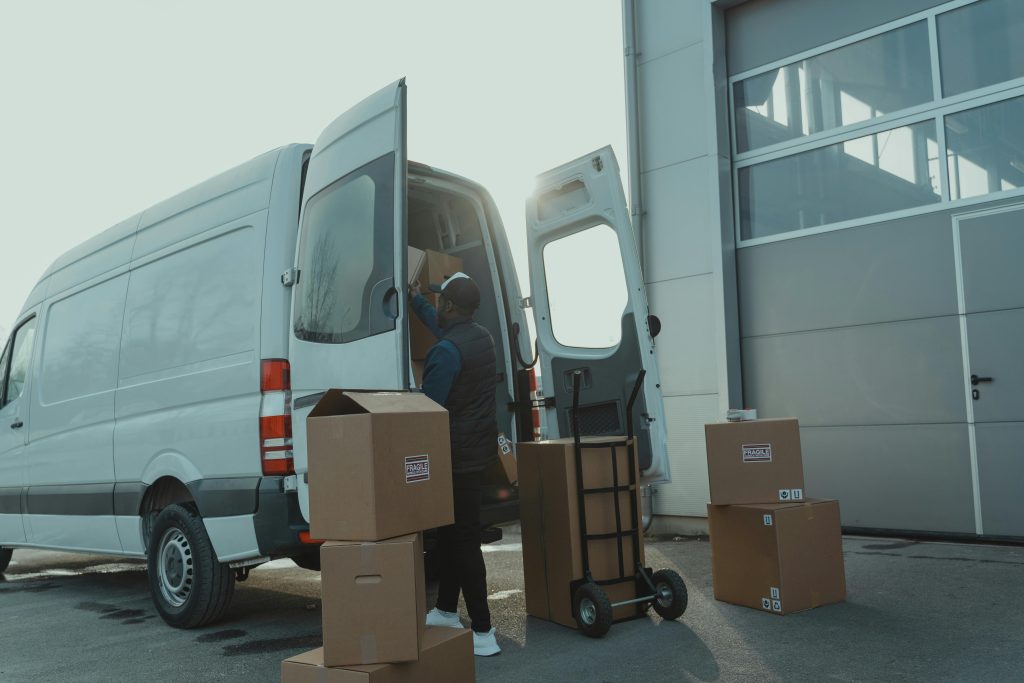 Delivery driver unloading cardboard boxes from a cargo van